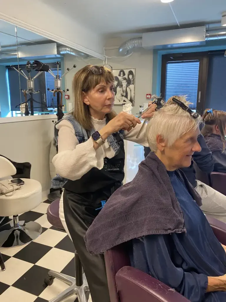 Frisørmester og salongeier Karin Hammer har femti år bak seg som frisør. Hun kunne ha pensjonert seg for lengst, men har stor glede av å jobbe, og hun trives sammen med kundene, forteller hun. Her klipper hun håret til NVLs utsendte medarbeider.